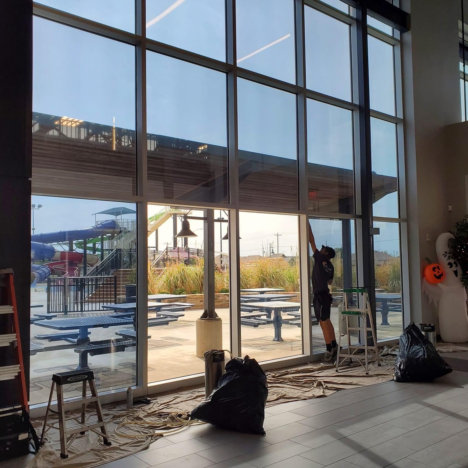 Window film installation on large business water park lobby before and after affect 
