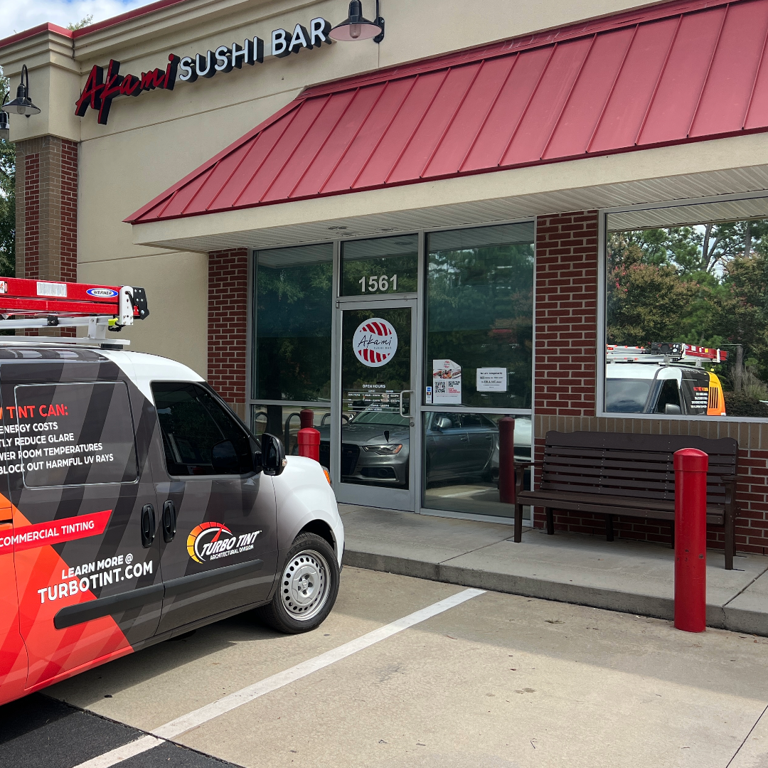 Turbo tint van parked outside a sushi bar with red awning after reflective window film installation