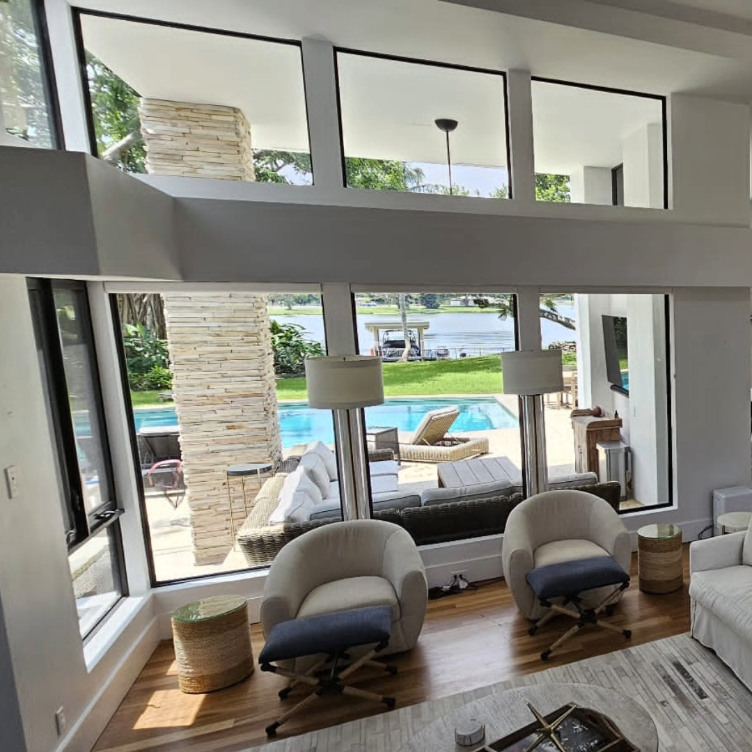 Modern living room with large windows overlooking a pool and garden no need for shades or curtains reduce the heat with window film to keep clean look