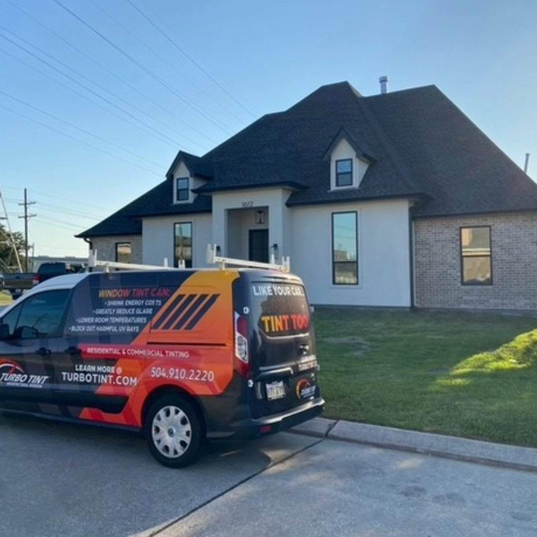Turbo Tint van parked in front of a house with clear blue sky after window tint installation reflective film